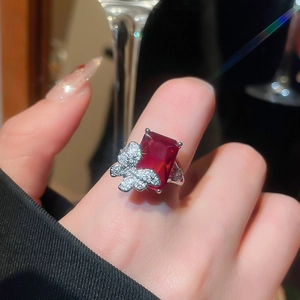 Detailed close-up of luxurious silver butterfly ring with large red ruby and pavé diamonds