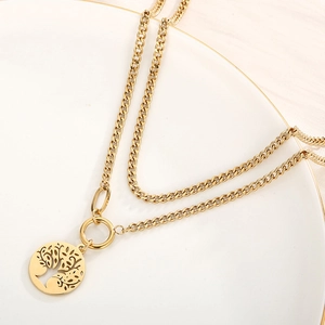 Macro shot of double-layer golden Cuban chain necklace featuring a Tree of Life pendant