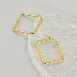 Minimalist square geometric gold-plated stainless steel hoop earrings on textured coaster