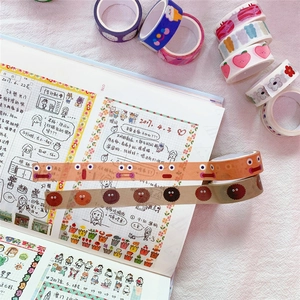 Close-up of decorative washi tapes with cute cartoon patterns on an open journal