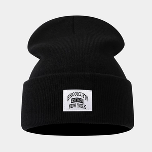Close-up of the woven Brooklyn patch on a black knit beanie with clear texture