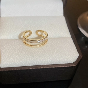 Macro shot of 18K gold plated bow ring with white enamel inlay in jewelry box