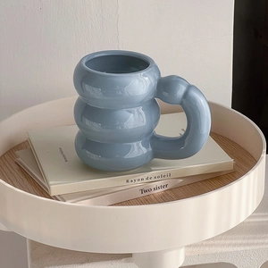 Minimalist blue bubble ceramic coffee mug with large handle on white tray display