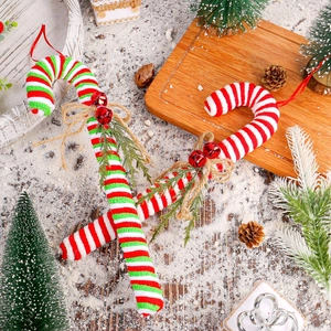 Christmas candy cane ornaments with festive pine needles, red bells and rustic bows