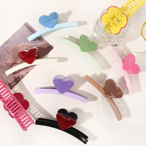 Flat lay of colorful heart-shaped shark hair claws on a stylish aesthetic background