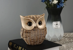 Detailed close-up of a resin owl ornament with woven texture on a decorative book