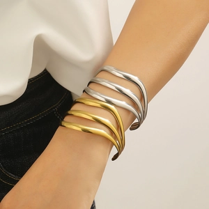 Gros plan de bracelets multicouches ondulés en acier inoxydable finitions or et argent