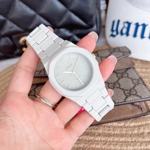 Close-up of white octagonal quartz watch with silicone strap and golden dial details