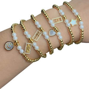 Handmade stretch bracelets set with gold beads, pearls, cross and heart charms