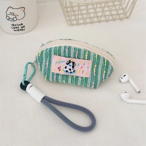 Close-up of green knitted earphone pouch with pink label and blue woven wrist strap