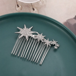 Silver snowflake alloy hair comb with rhinestones on a green ceramic plate