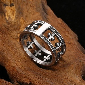 Gros plan sur une bague médiévale en argent avec motif croix évidé sur bois naturel