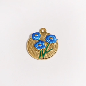 Detailaufnahme eines goldenen Blumenanhängers mit blauen Emaille-Blumen und Blättern
