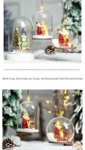 Detail of Christmas glass dome ornament with warm LED lights and miniature Santa scene