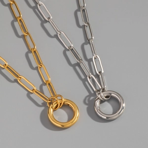 Detail view of gold and silver chain necklaces with large spring clasps on gray background
