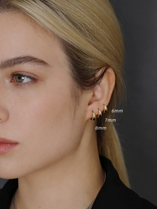 Close-up of three 925 silver golden hoop earrings in 6mm, 7mm, and 8mm sizes