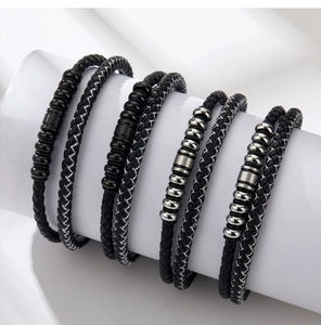 Close-up of multilayer braided leather bracelets with steel magnetic clasps and beads