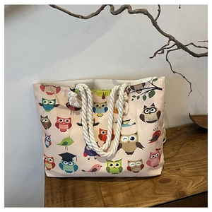 Detailed view of canvas tote bag with owl prints and rustic thick hemp rope handles