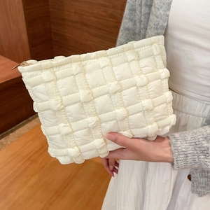 Quilted cloud puffer makeup bag in ivory canvas with 3D decorative grid and gold zipper
