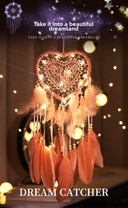Detail of pink heart dream catcher with soft feathers, wood beads and LED fairy lights