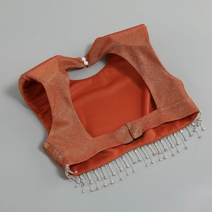 Dettaglio del top arancione rosso con paillettes, frange di cristallo e bottoni