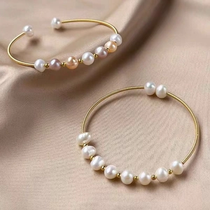 Ethnic style gold hand-wrapped wire pearl bracelets set on champagne silk background
