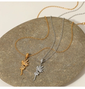 Detail of silver and gold fairy wing pendants with zircons on natural grey stone