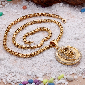 Close-up of a gold-plated lion head pendant with sparkling rhinestones on a box chain