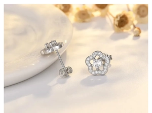 Detailed macro shot of silver flower stud earrings with sparkling cubic zirconia inlay