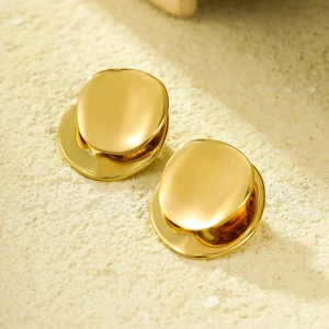Minimalist geometric round stainless steel earrings in gold finish on stone surface