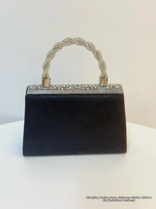 Close-up of black suede evening bag featuring crystal-encrusted twisted handle and trim