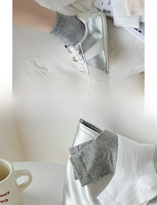 Detail of ribbed knit cotton socks in grey and white paired with silver sneakers