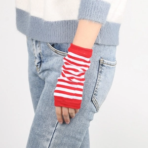 Macro detail of red and white striped knit wrist warmers with ribbed texture details