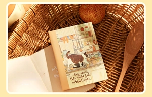Close-up of A7 mini notebook featuring a charming cat kitchen illustration