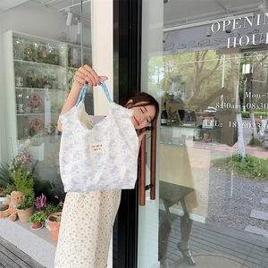 Detail of cartoon bear canvas tote bag with zakka beauté label and blue woven handles