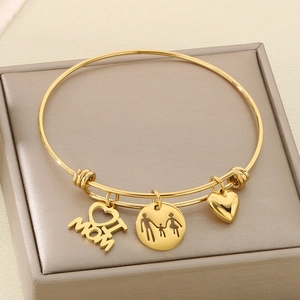 Detail of adjustable gold bangle featuring MOM heart and parent-child silhouette pendants