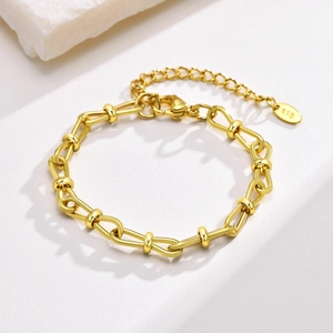 Detail of 18K gold plated Figaro bracelet with lobster clasp and K18 purity tag on stone