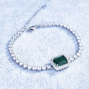 Detailed view of emerald cut green gemstone bracelet with sparkling micro pave diamonds