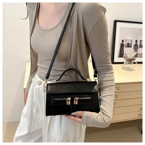 Detail of black PU leather shoulder bag featuring dual front zipper pockets and gold locks