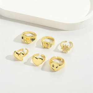 Detailed view of six vintage gold-plated rings with heart, star, and gemstone designs