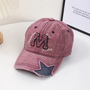 Vintage washed cotton baseball cap with embroidered M logo and star patch in dusty pink