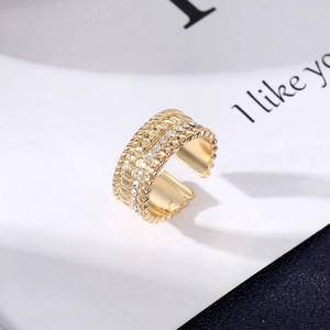 Macro view of gold evil eye ring featuring wavy edges and rows of white zircons