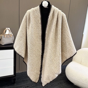 Elegant beige knitted shawl wrap with dark brown sawtooth edge stitching on a mannequin