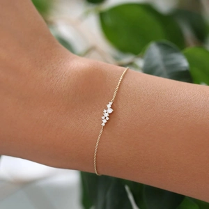 Close-up of minimalist gold sterling silver bracelet with small clustered diamonds on wrist