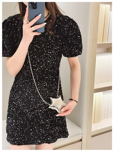 Detailed view of a shiny star-shaped metal mini bag with a slim beaded silver chain strap