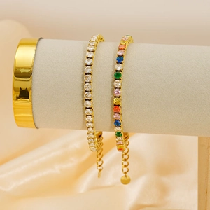 Jonc ouvert doré et bracelets tennis en zircons colorés sur support à bijoux