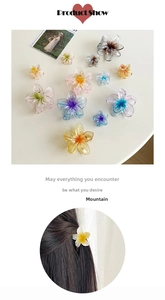 Detailed view of large gradient plumeria hair claws showing various colors and sizes