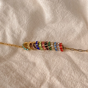 Détail du collier en or avec des pendentifs ronds ornés de strass multicolores fins