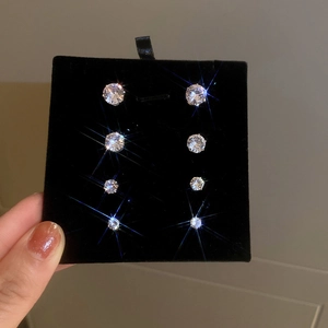 Detail showing four pairs of silver-tone zircon magnetic stud earrings in graduated sizes
