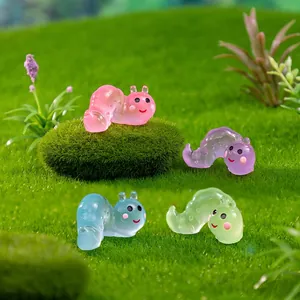 Cute colorful glow caterpillars on green moss for DIY miniature fairy garden landscaping